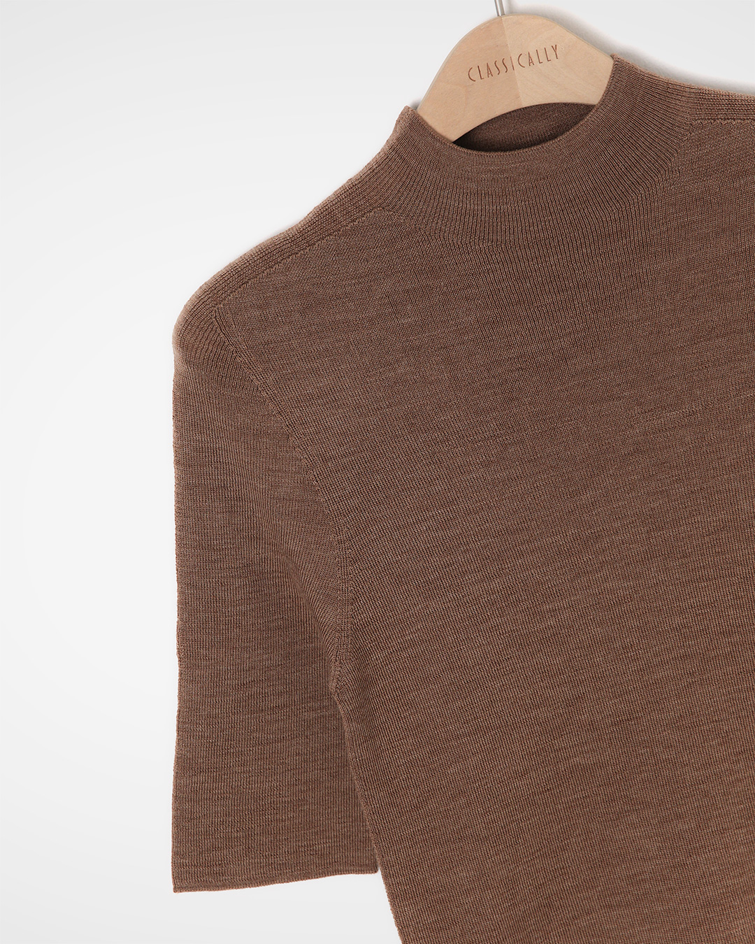 The neatness of the half-high neckline,<br> And the delicate warmth provided by 100% wool