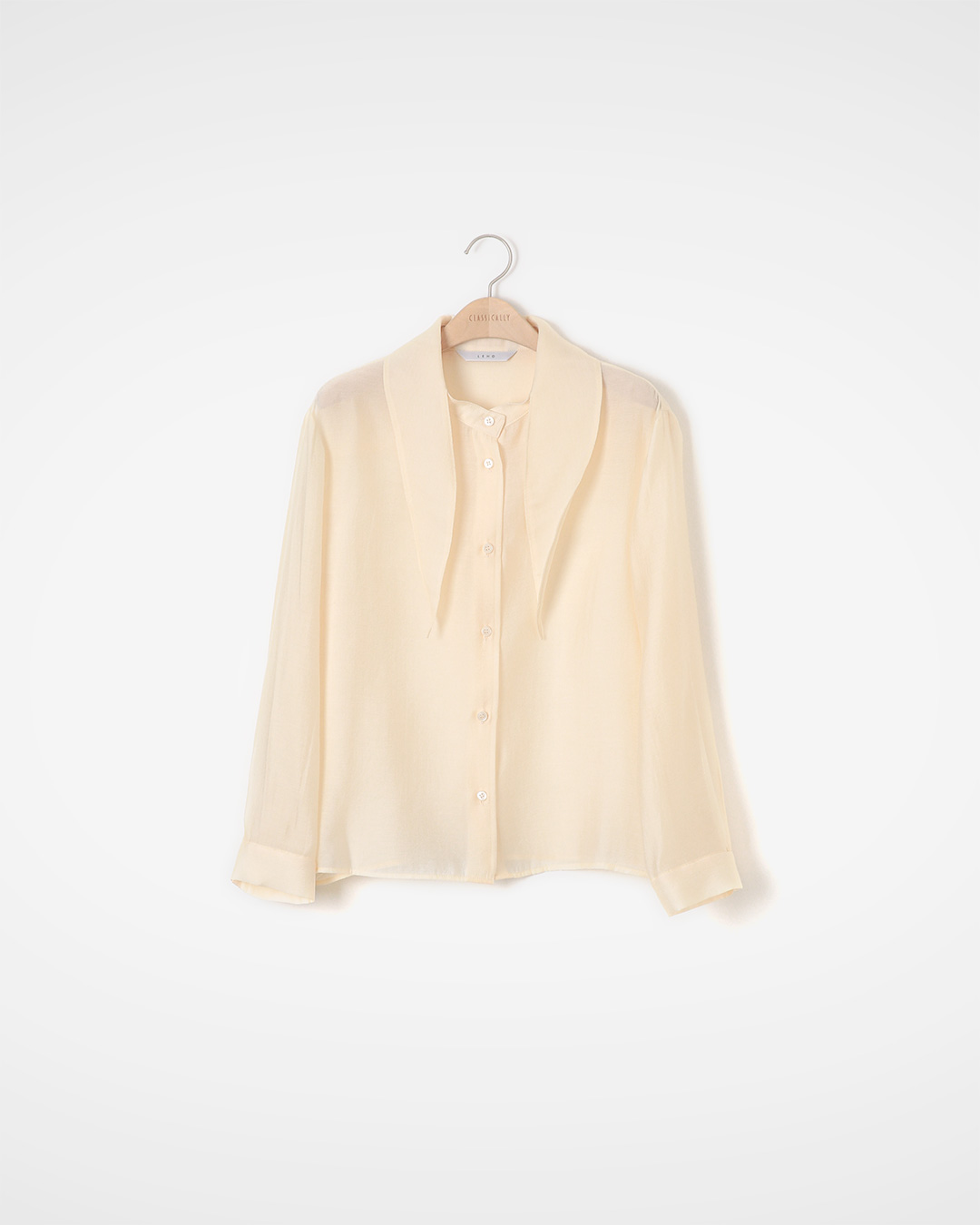 Flowing silhouette and simple details<br> rayon blend tie-neck blouse